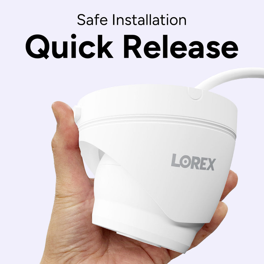 Hand holding a white Lorex quick-release security camera against a pale lavender background