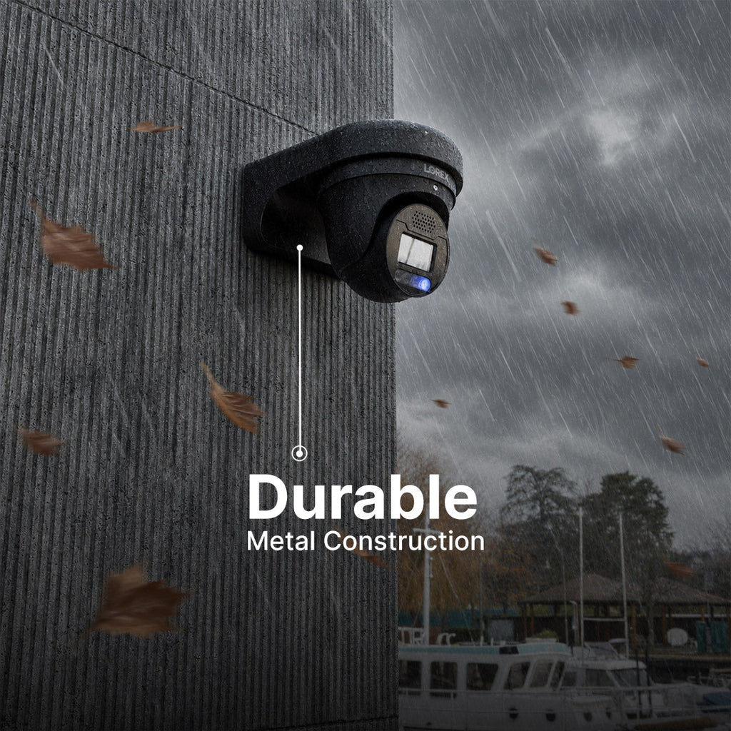 Black weatherproof security camera mounted to a rain soaked textured concrete wall