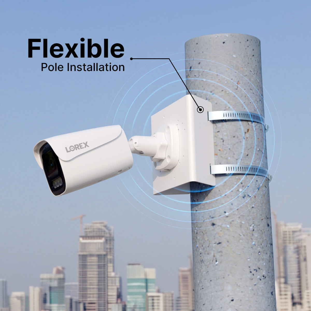Security camera attached to a pole with two metal straps for flexible pole installation in an urban setting.
